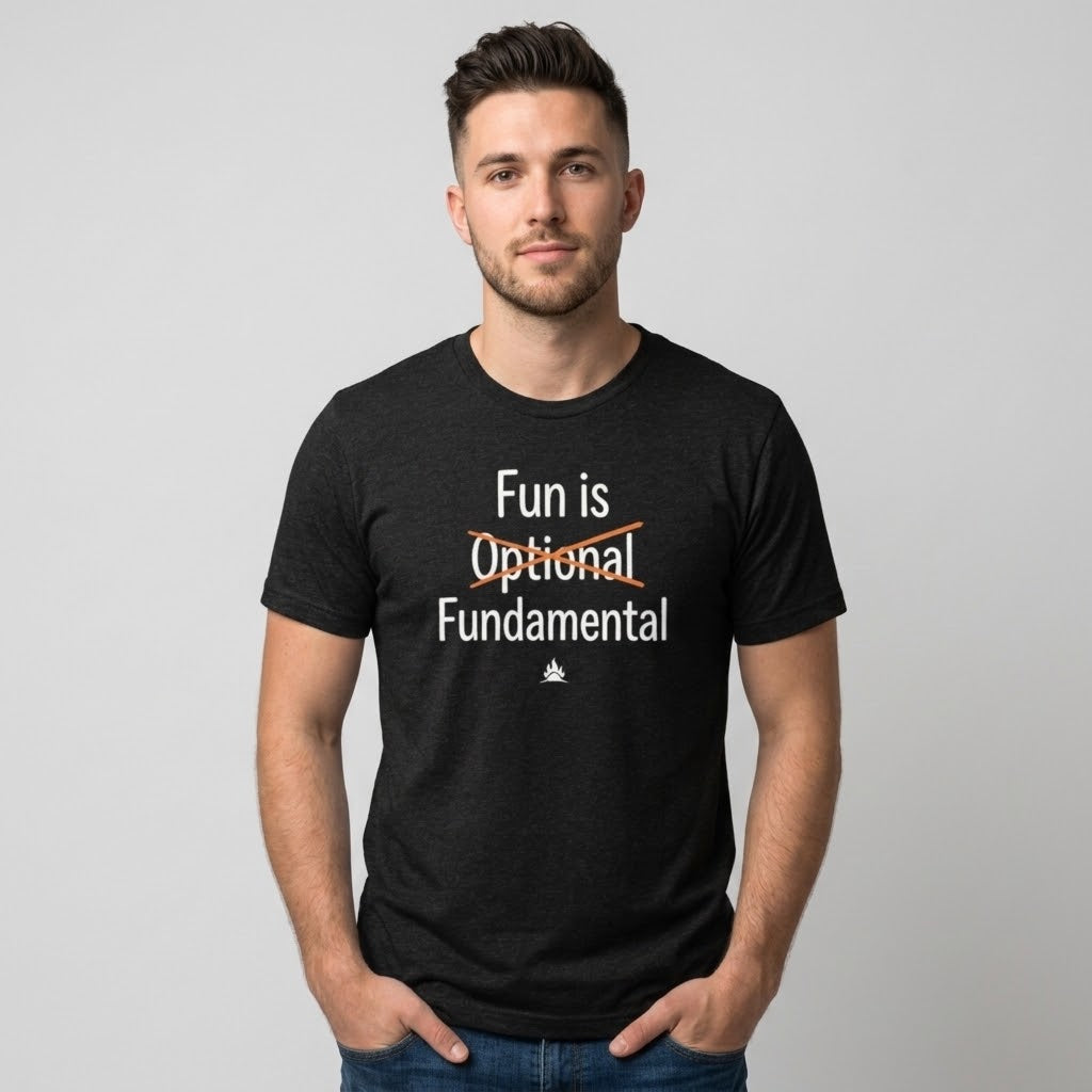 A man wearing a black graphic t-shirt with the text 'Fun is Optional Fundamental' printed on the chest, posed against a neutral gray background.